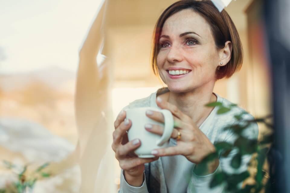 Smiling woman looking out of window