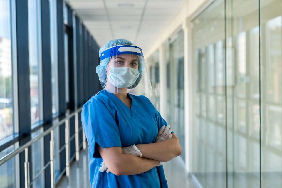 Female medical professional standing with arms crossed