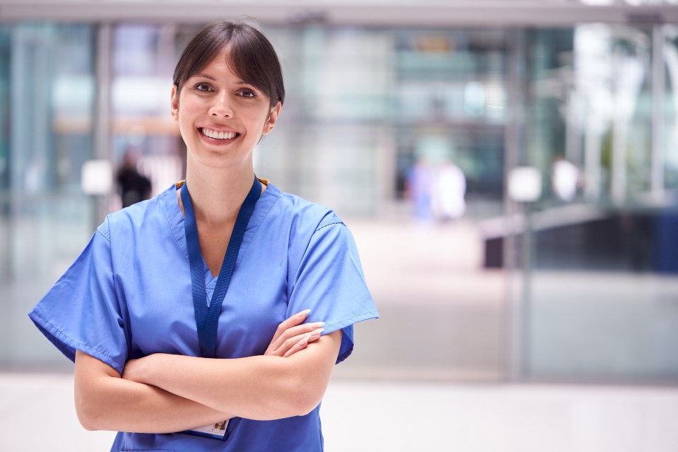 Female nurse standing with crossed arms and smiling